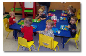 Happy young students eating at a blue table